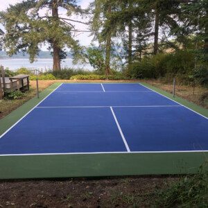End view of a backyard pickleball court overlooking the river